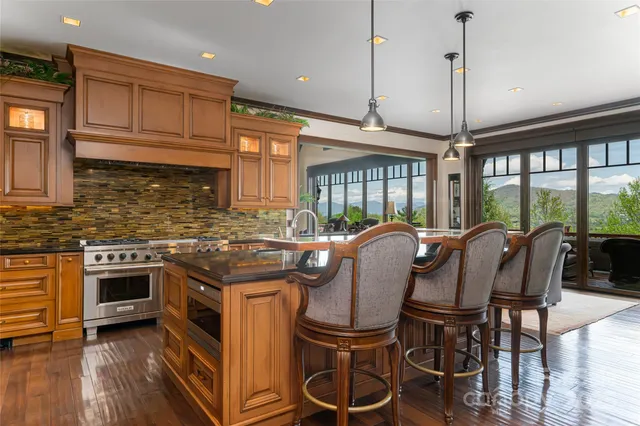 a kitchen with granite countertop a stove a sink and a wooden floor