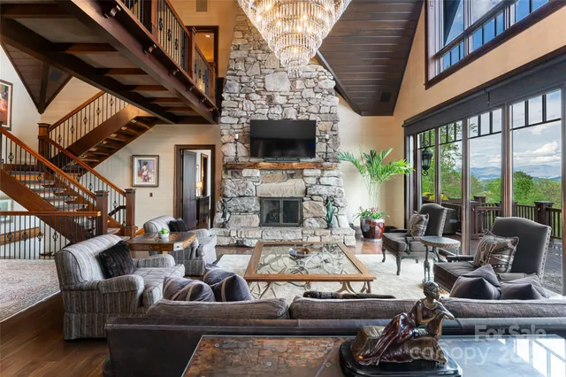 a living room with furniture a fireplace a rug and a large window