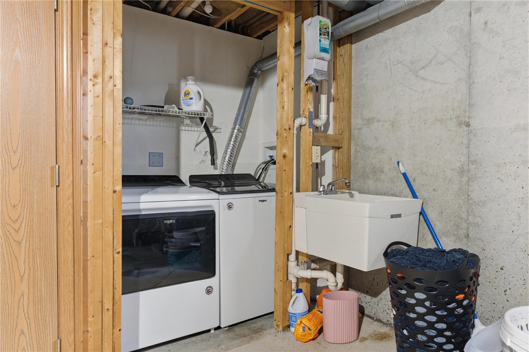 8747 Waynes Way Blanchester, OH 45107 - Photo 25 of 40 This functional utility space features a laundry area with essential appliances and a convenient wash sink.