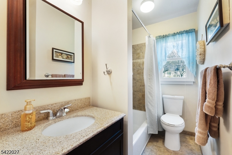 248 Perry Street Dover, NJ 07801 - Photo 14 of 24 a bathroom with a granite countertop toilet sink and mirror