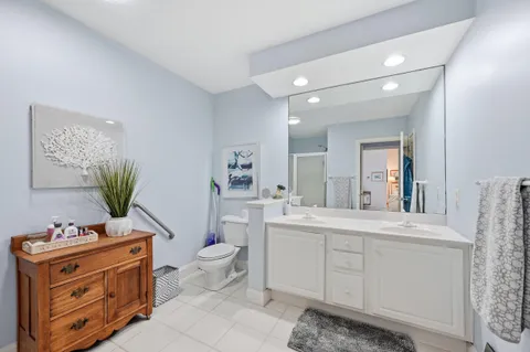 a spacious bathroom with a granite countertop toilet sink and mirror