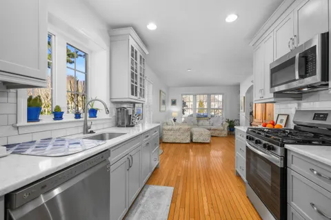 a large kitchen with stainless steel appliances a stove a sink and a microwave