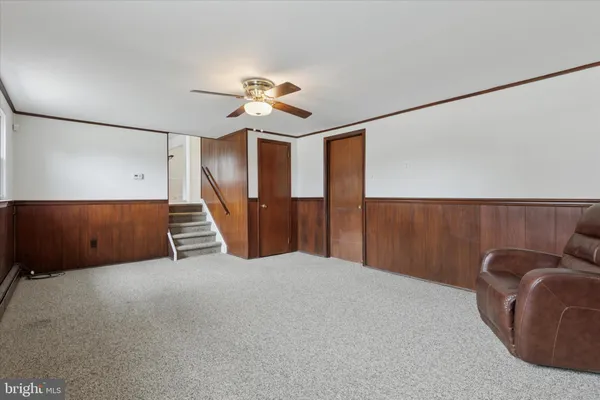 a view of a livingroom with furniture & staircase