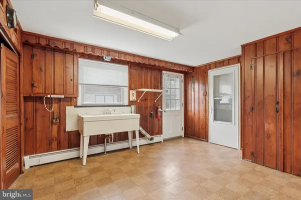 a view of an empty room with cabinet and a window