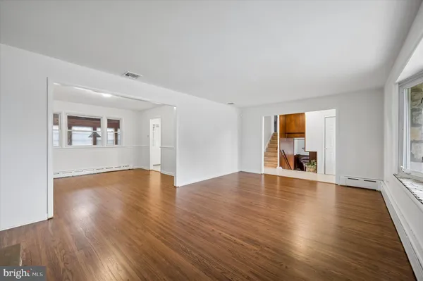 a view of empty room with wooden floor and fireplace