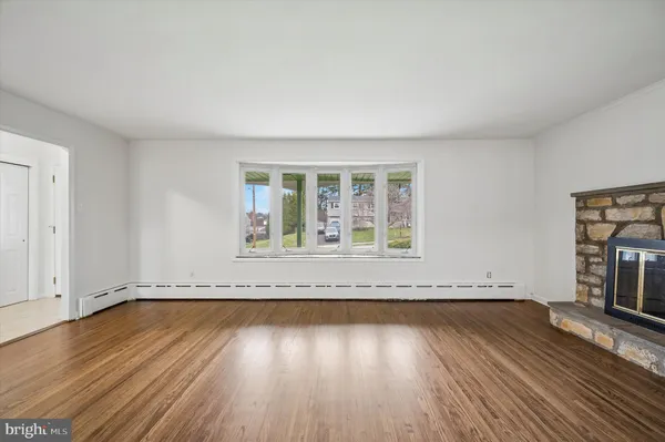 an empty room with wooden floor and window