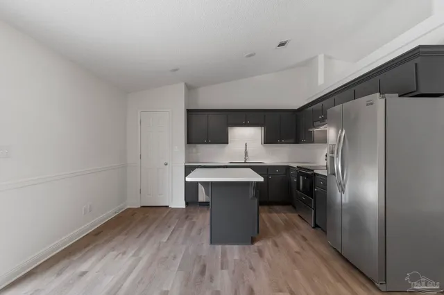a kitchen with a refrigerator and a sink