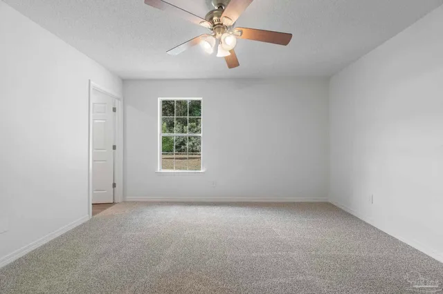 an empty room with a window and a fan