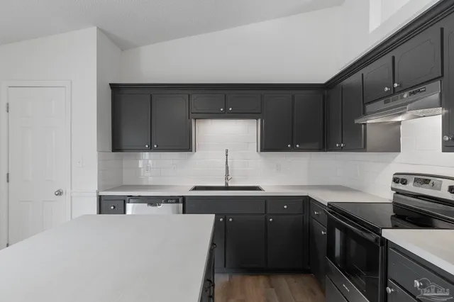 a kitchen with stainless steel appliances a sink stove and cabinets