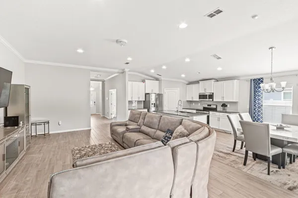 a living room with furniture wooden floor and a flat screen tv