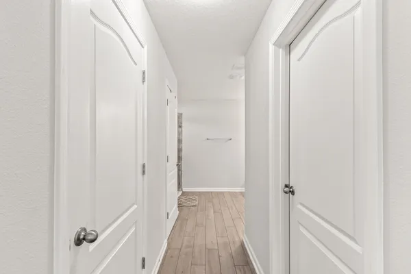 a view of a hallway with wooden floor