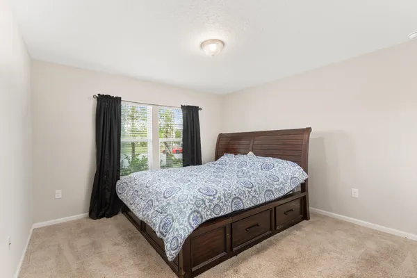 a bed sitting in a bedroom next to a window
