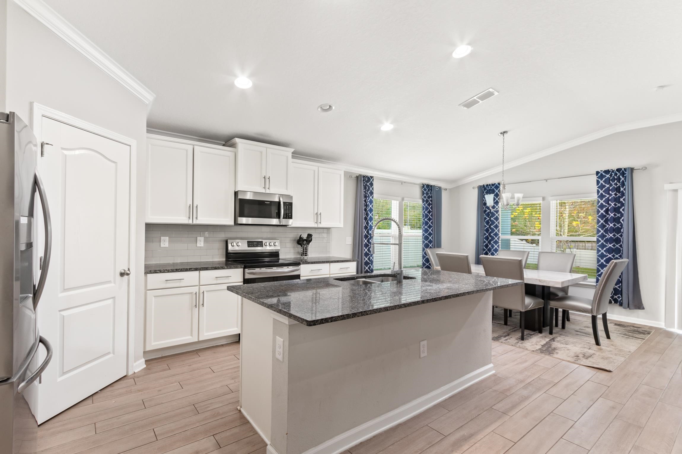 392 South Hamilton Springs Road St. Augustine, FL 32084 - Photo 2 of 29 a kitchen with stainless steel appliances granite countertop a stove a sink a refrigerator and white cabinets with wooden floor