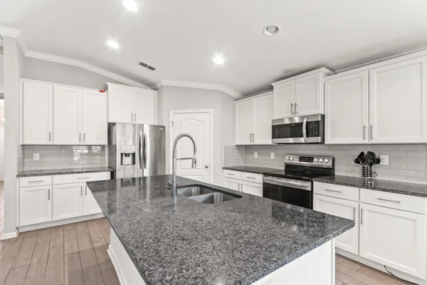 a kitchen with stainless steel appliances granite countertop a sink stove and refrigerator