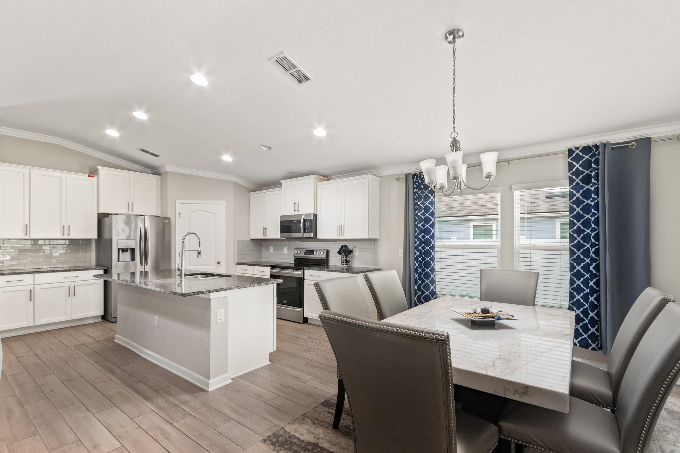 392 South Hamilton Springs Road St. Augustine, FL 32084 - Photo 8 of 29 a kitchen with stainless steel appliances kitchen island granite countertop a table chairs and a refrigerator