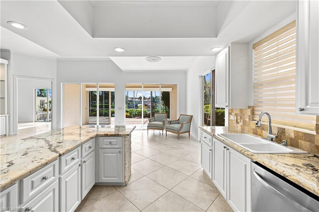 4470 Novato Court Naples, FL 34109 - Photo 7 of 33 Kitchen featuring white cabinetry, light-toned countertops, a stainless steel sink, and tile flooring