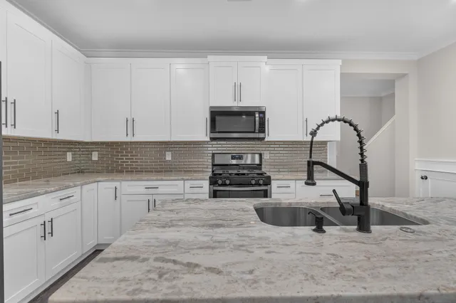 a kitchen with stainless steel appliances a stove a sink a microwave and cabinets