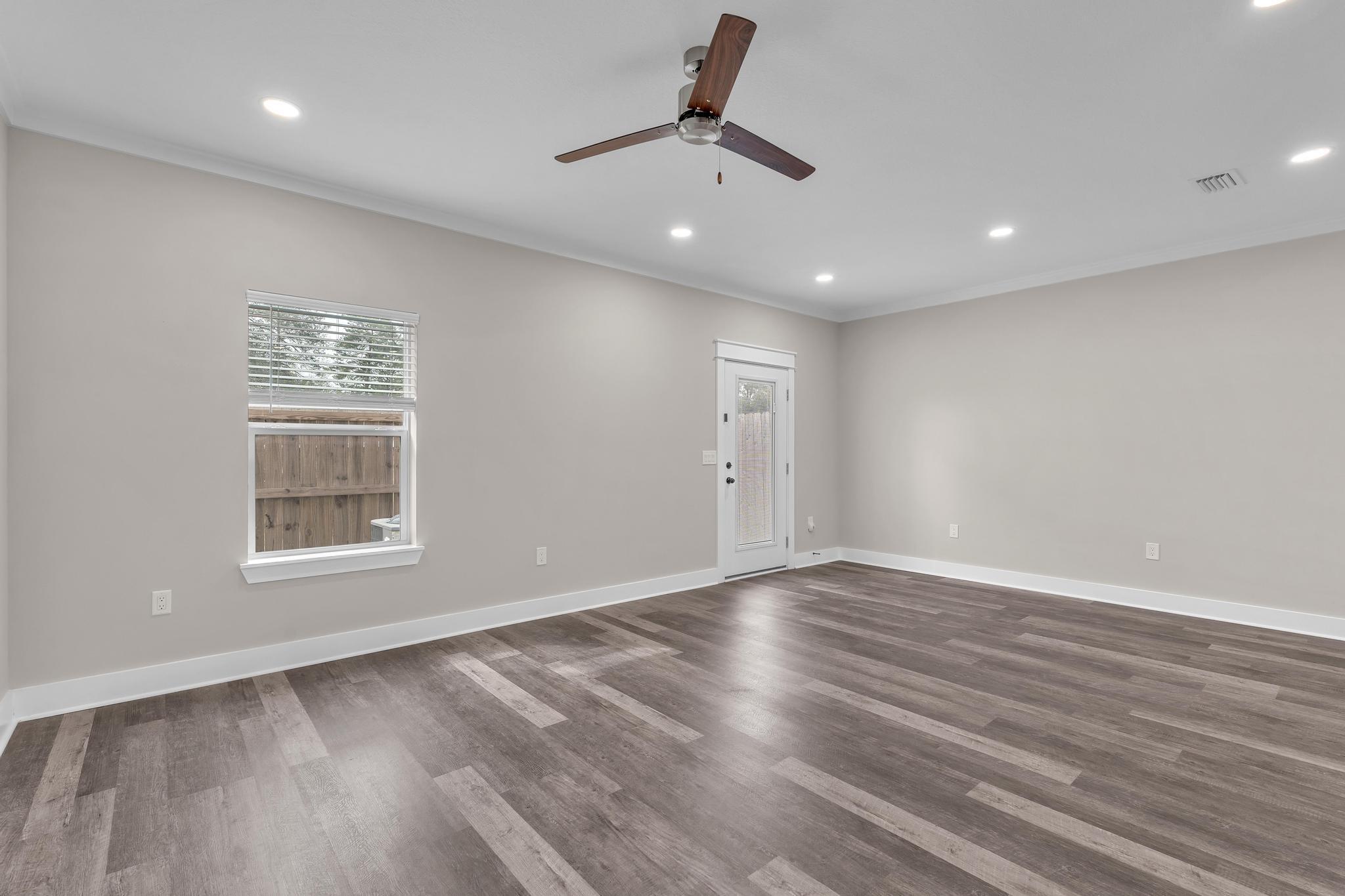 2 Praiseworthy Drive Valparaiso, FL 32580 - Photo 14 of 36 an empty room with wooden floor chandelier fan and windows