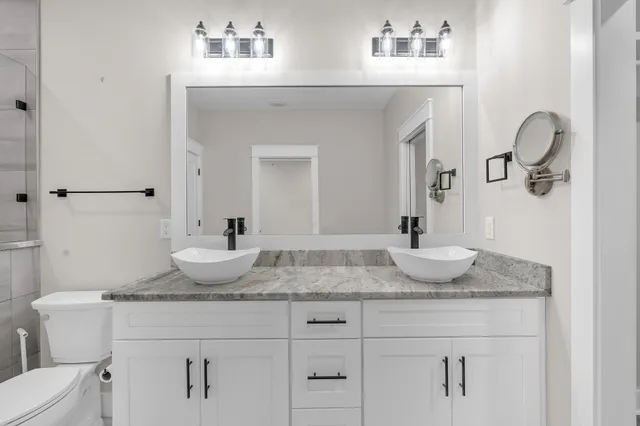 a bathroom with a granite countertop sink and a mirror