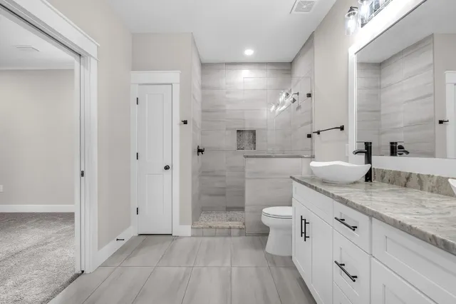 a spacious bathroom with a granite countertop sink a toilet and shower