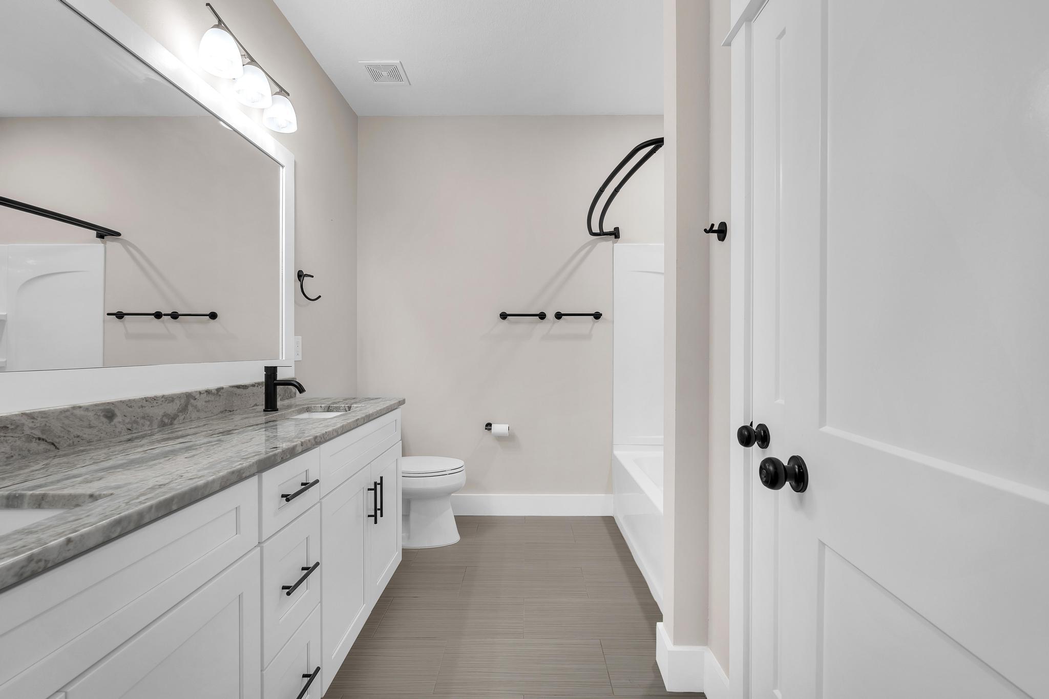 2 Praiseworthy Drive Valparaiso, FL 32580 - Photo 25 of 36 a bathroom with a granite countertop sink a toilet and a mirror