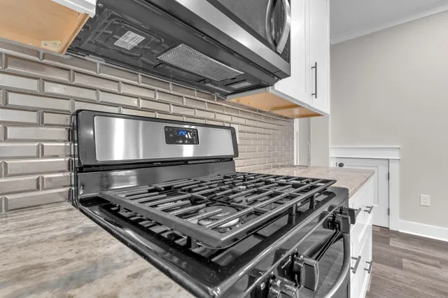 a stove sitting inside of a kitchen with stainless steel appliances