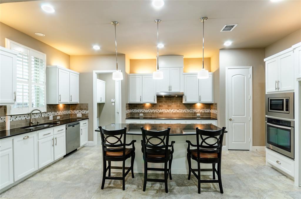 1863 Audubon Pond Way Allen, TX 75013 - Photo 3 of 40 a kitchen with granite countertop a table chairs sink refrigerator and microwave