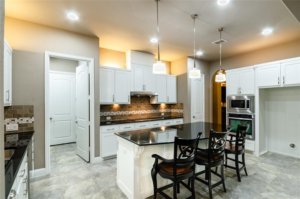 1863 Audubon Pond Way Allen, TX 75013 - Photo 4 of 40 a kitchen with kitchen island a refrigerator and a stove top oven