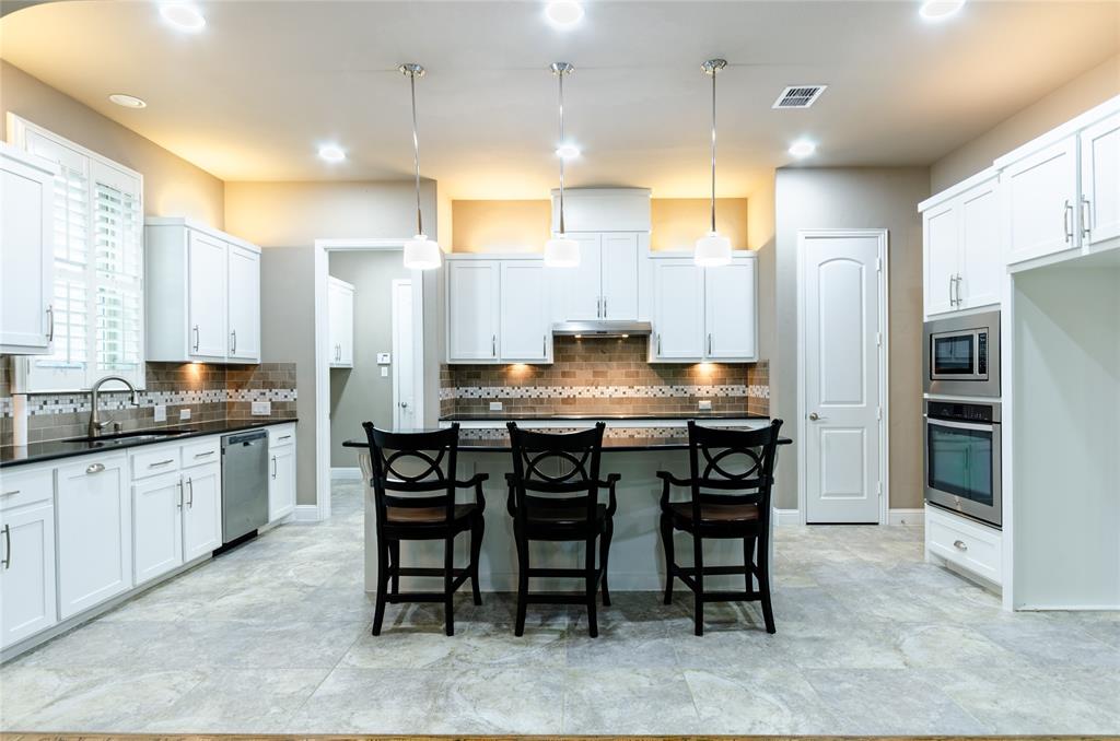 1863 Audubon Pond Way Allen, TX 75013 - Photo 8 of 40 a kitchen with stainless steel appliances granite countertop a table chairs sink refrigerator and microwave