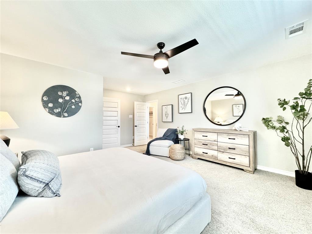 8523 Leyton Road The Colony, TX 75056 - Photo 20 of 39 a bedroom with a bed and a chandelier