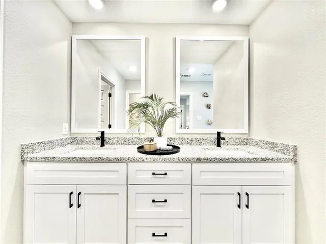a bathroom with a granite countertop sink and a mirror