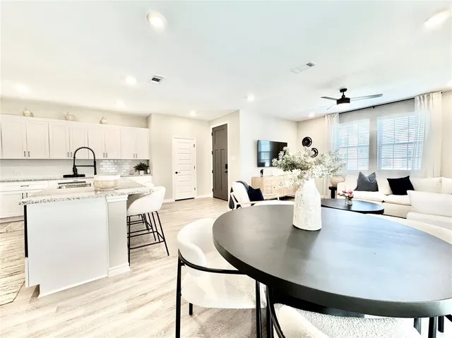 a kitchen with a table chairs and white appliances