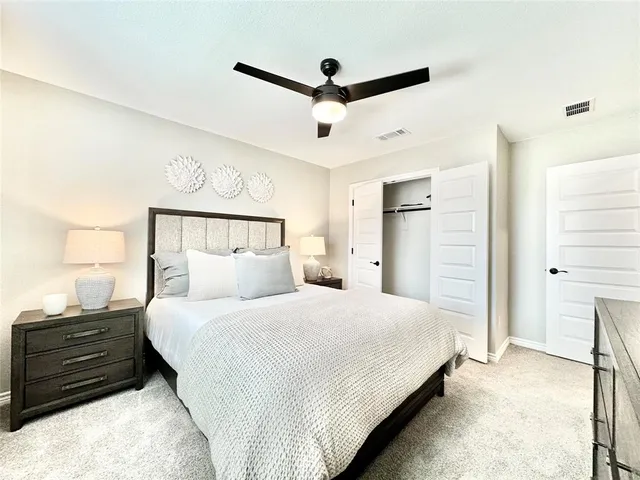 a bedroom with a bed and a ceiling fan
