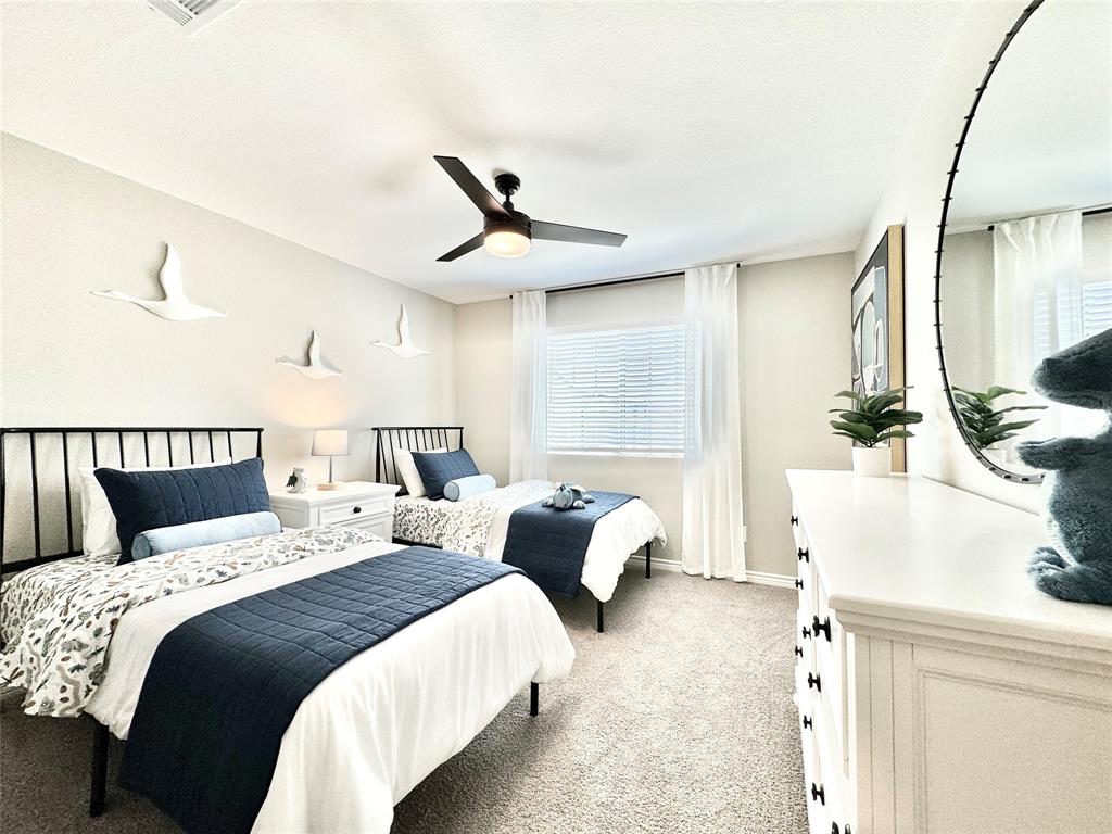 8523 Leyton Road The Colony, TX 75056 - Photo 32 of 39 a bed room with two beds and a chandelier