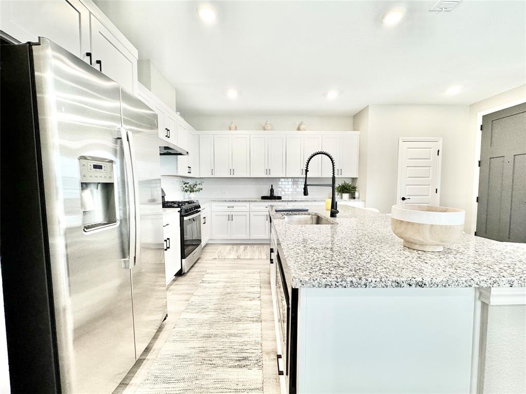 8523 Leyton Road The Colony, TX 75056 - Photo 6 of 39 a kitchen with stainless steel appliances granite countertop a sink stove and refrigerator