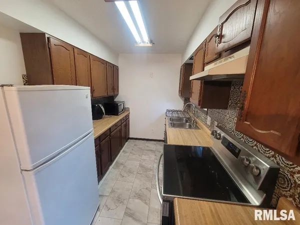 a kitchen with a refrigerator and a stove