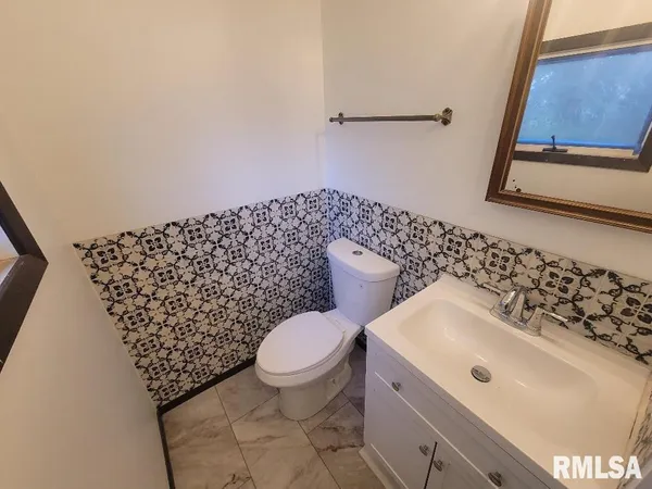 a bathroom with a sink toilet and a mirror