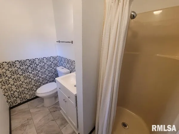 a bathroom with a toilet and a shower