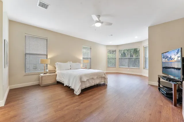 a spacious bedroom with a bed and wooden floor