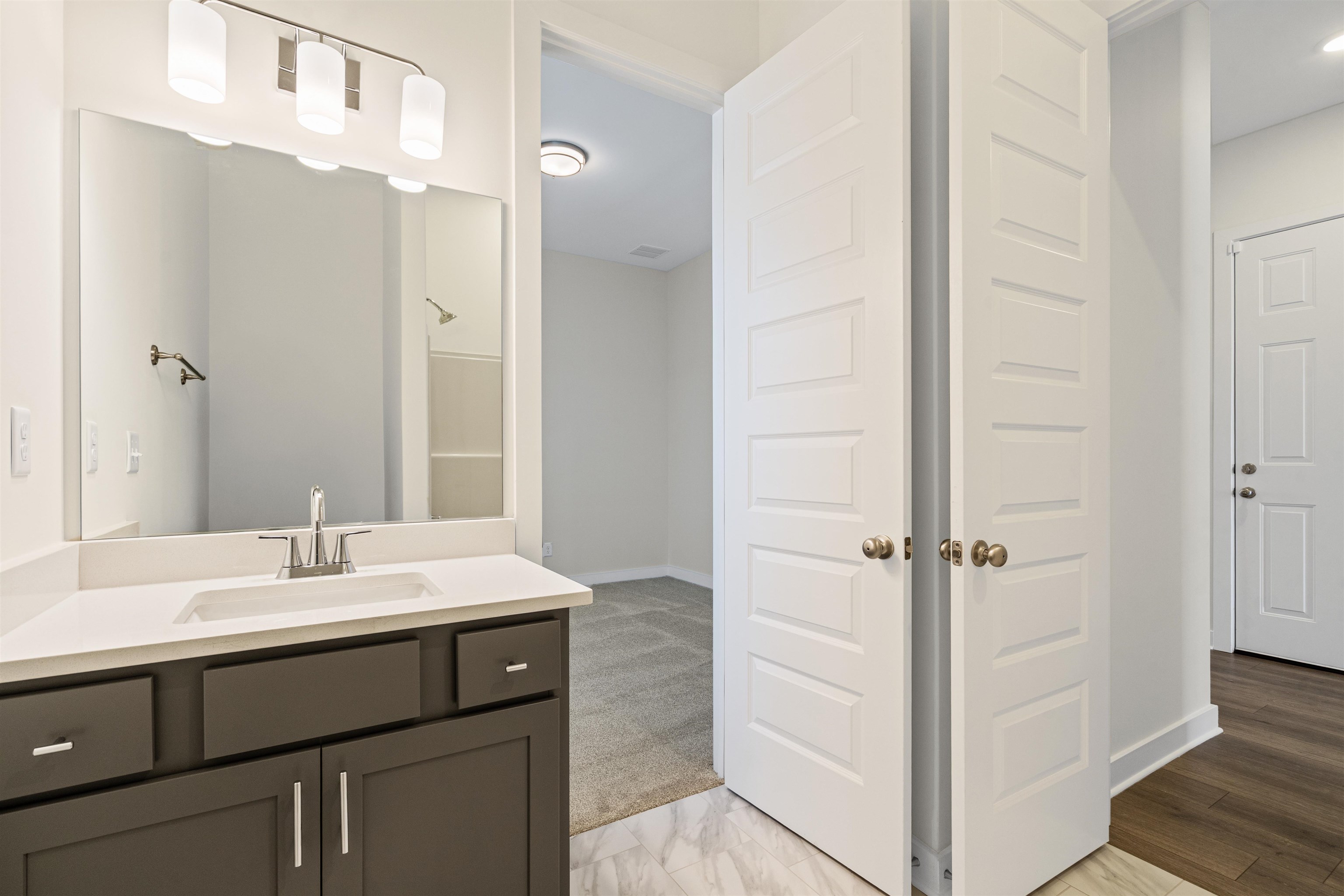 5666 Pleasant Pk Place Arlington, TN 38002 - Photo 7 of 27 Bathroom vanity featuring a rectangular undermount sink, a white countertop, and dark cabinetry with brushed nickel hardware