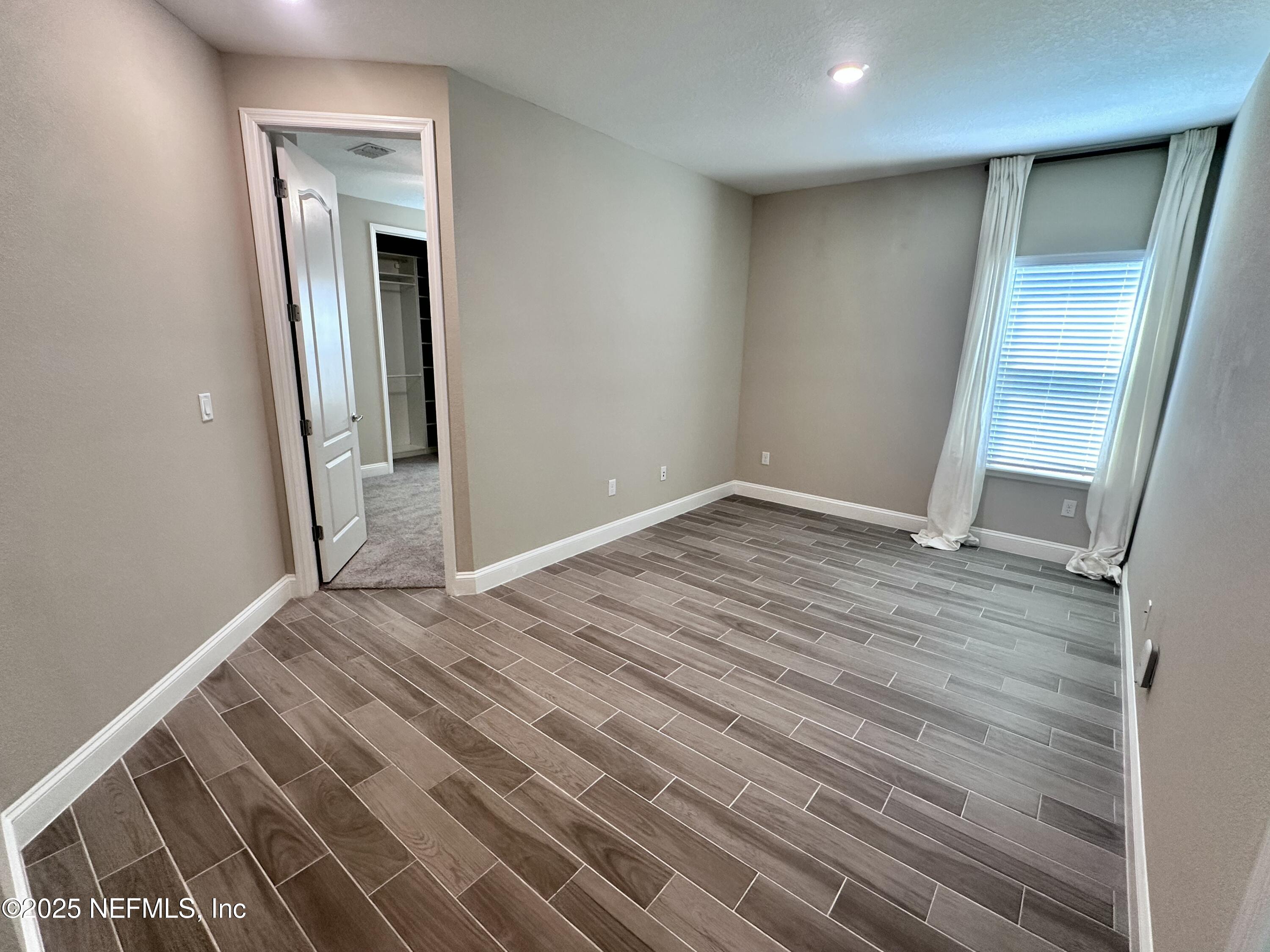 510 Broomsedge Circle St. Augustine, FL 32095 - Photo 11 of 28 an empty room with wooden floor and entrance