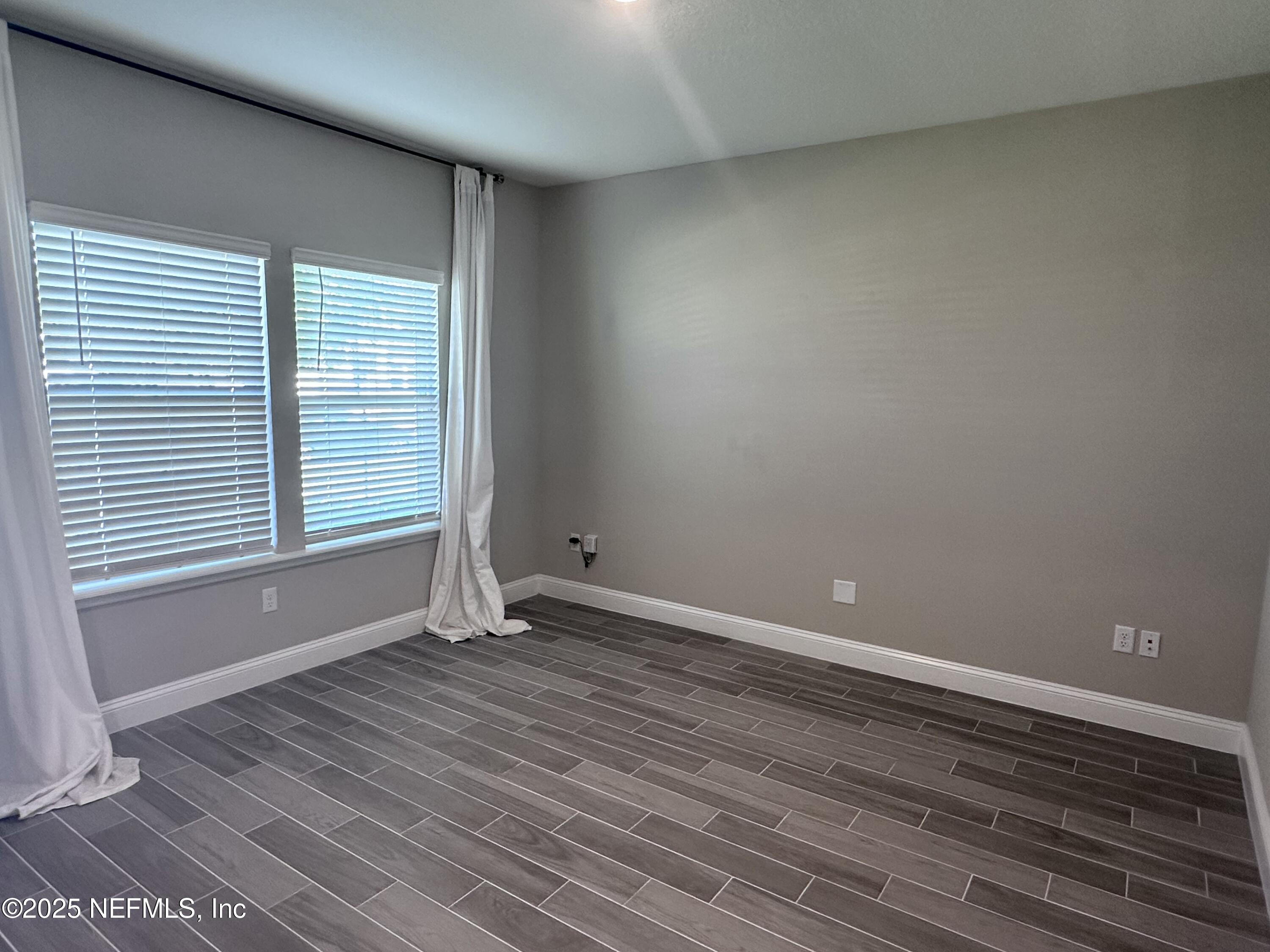 510 Broomsedge Circle St. Augustine, FL 32095 - Photo 4 of 28 a view of an empty room with wooden floor and a window
