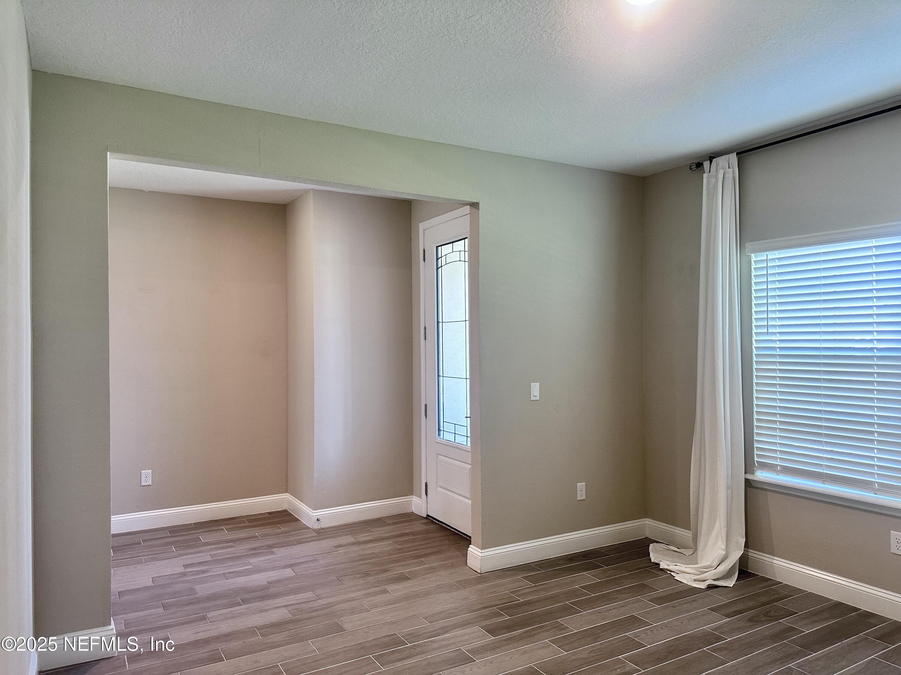 510 Broomsedge Circle St. Augustine, FL 32095 - Photo 5 of 28 an empty room with wooden floor and windows