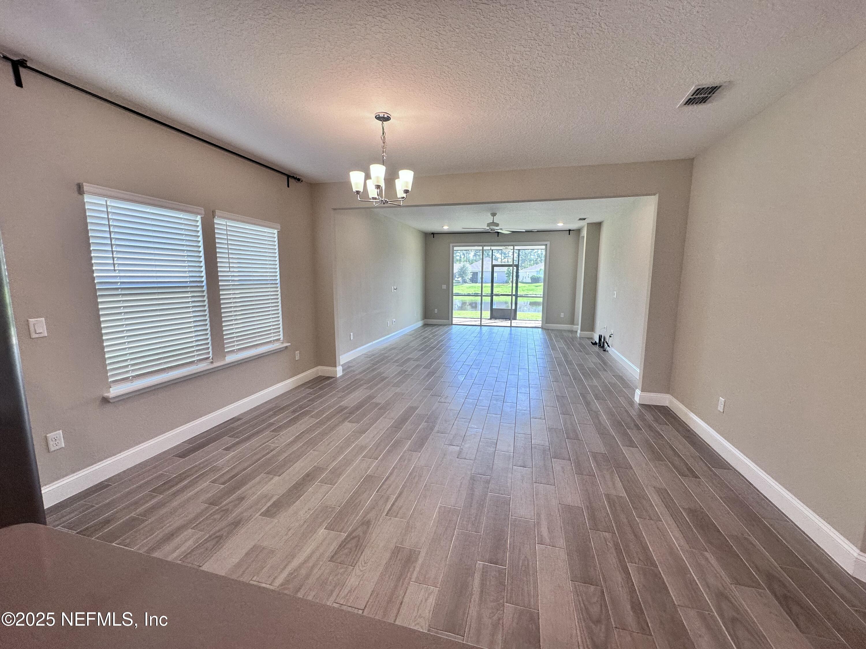 510 Broomsedge Circle St. Augustine, FL 32095 - Photo 9 of 28 wooden floor in an empty room with a window