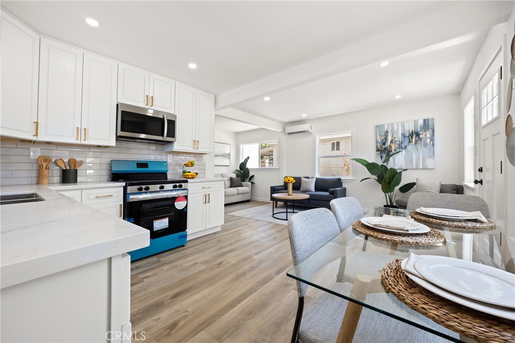 220 South Harris Avenue Compton, CA 90221 - Photo 11 of 28 a kitchen with stainless steel appliances stove refrigerator dining table and chairs