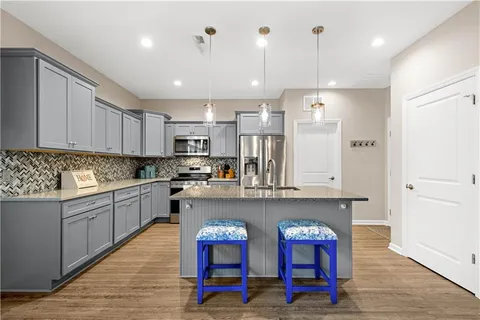 a kitchen with stainless steel appliances granite countertop a sink and a refrigerator