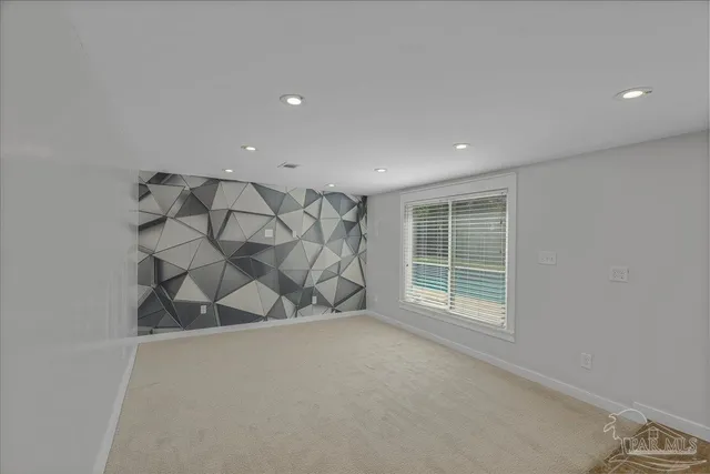 an empty room with wooden floor ceiling fan and windows