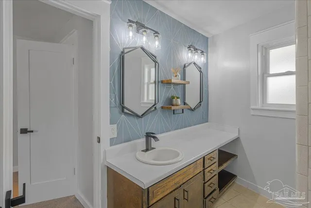 a bathroom with a granite countertop sink and a mirror