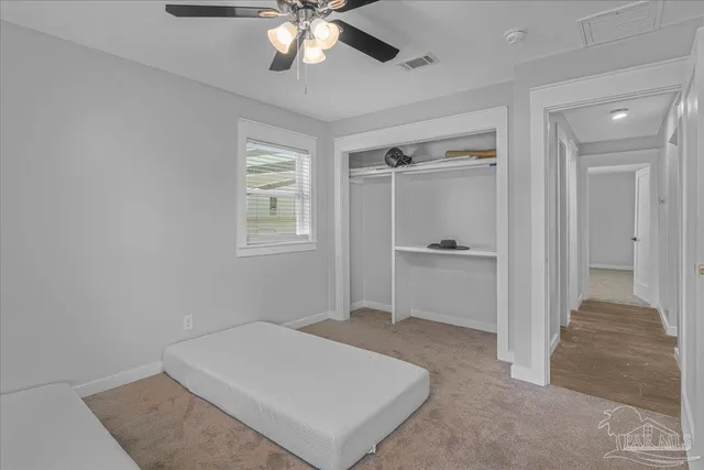 an empty room with windows and fan