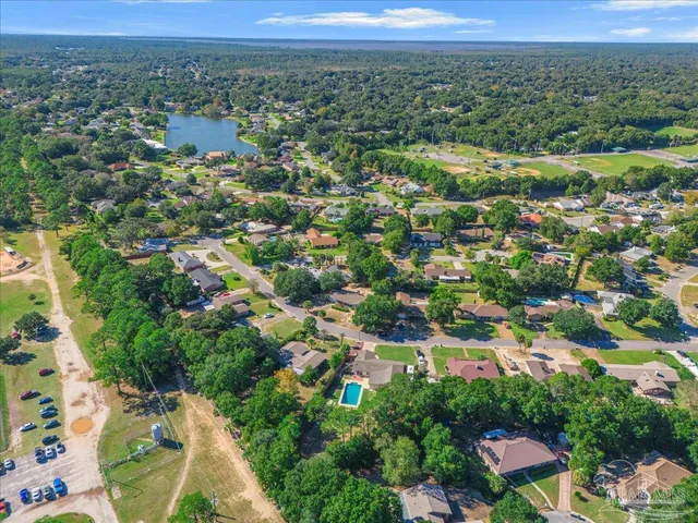 an aerial view of residential houses with outdoor space and trees